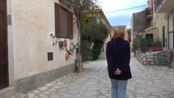意大利西西里斯科佩罗一个女游客在这个小村庄的鹅卵石街上散步 — 图库视频影像