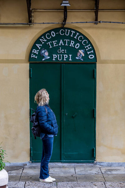 Palermo, Sicily, Italy Jan 12, 2024 A woman tourist stands at the entrance to a Puppet Theater, Teatro dei Pupi.