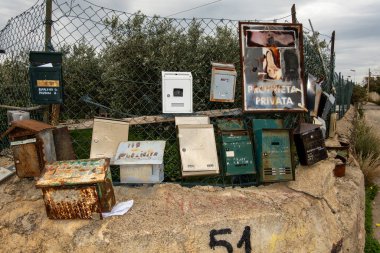 Palermo, Sicilya, İtalya 17 Ocak 2024 Bir sokak köşesinde paslı eski posta kutuları koleksiyonu Ve özel mülk diyen bir İtalyanca imza.