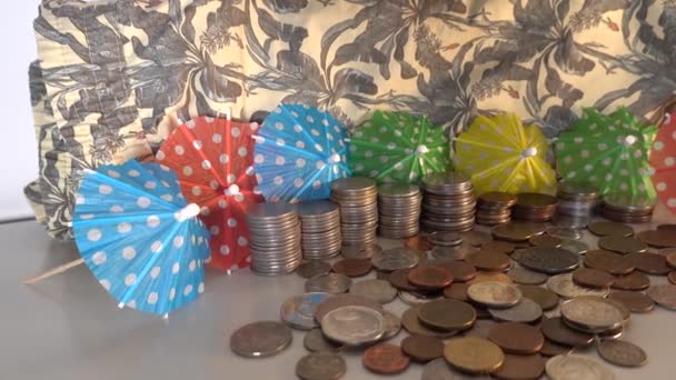 一堆硬币和阳伞象征着金钱和异国情调的度假 — 图库视频影像