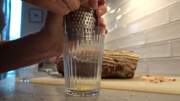一个女人把厨房里的生姜磨成玻璃杯 和果汁混合在一起 — 图库视频影像