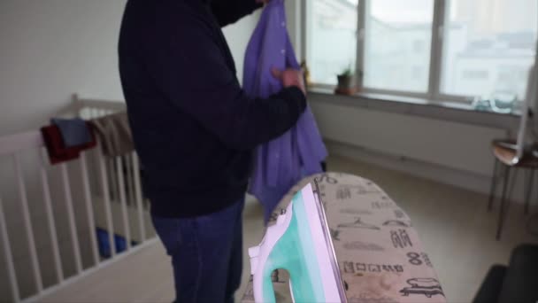 Homem Passa Uma Camisa Azul Num Apartamento — Vídeo de Stock