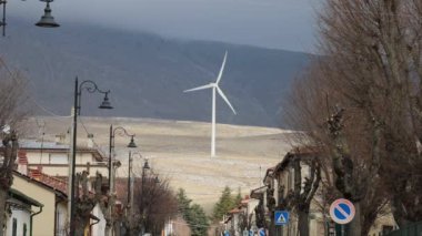 Yaka, Abruzzo, İtalya Yağmurda ve siste dağların tepelerinde rüzgar türbinleri dönüyor.