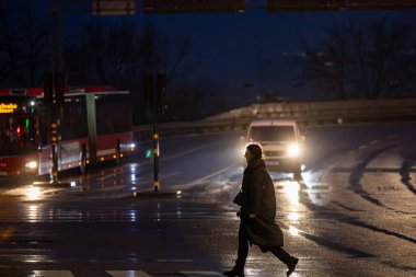 Stockholm, İsveç 24 Şubat 2024. Hornstull bölgesinde bir kadın gece karşıdan karşıya geçiyor..