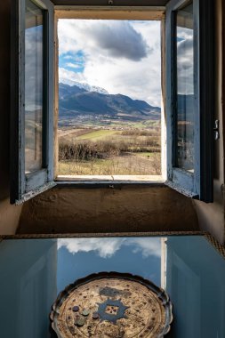 İtalya, Castel di Ieri. Monte Sirente dağları ve Abruzzo Milli Parkı 'nın manzarası açık bir pencereden görülüyor..