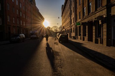 Stockholm, İsveç 11 Mart 2024 Heleneborgsgatan Sodermalm bölgesinde gün batımında bir bisikletçi.