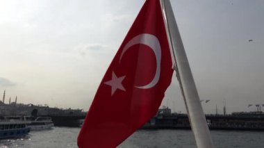 İstanbul, Türkiye Galata Köprüsü 'nün altındaki yolcu feribotunun arkasında Türk bayrağı dalgalandı.  