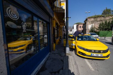 İstanbul, Türkiye 18 Mart 2024. Balat bölgesinde sarı bir evin önünde sarı bir taksi duruyor..