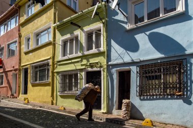 İstanbul, Türkiye 18 Mart 2024. Balat bölgesinde bir adam ağır bir patates çuvalı taşıyor..