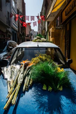 İstanbul, Türkiye 18 Mart 2024 Balat ilçesindeki bir arabanın kaputundan satılık Tiger Lilies gibi çiçekler.