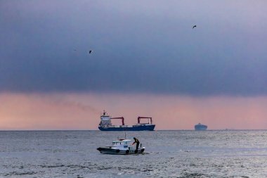 İstanbul, Türkiye 20 Mart 2023 İstanbul Boğazı 'nda bir konteyner gemisi ve küçük bir balıkçı teknesi. .