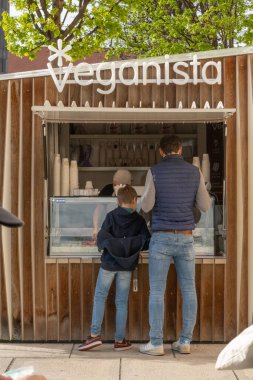 Vienna, Austria April 5, 2024 A father and son at a  Veganista snack bar at the Museum Quartier Wien. clipart