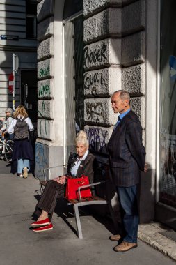 Viyana, Avusturya 5 Nisan 2024 Yaşlı bir çift Gumpendorfer Caddesi 'nde bir otobüs bekliyor..