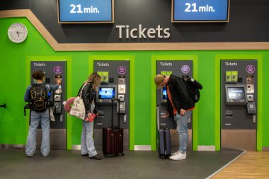 Viyana, Avusturya 5 Nisan 2024 İnsanlar yeşil şehir havaalanı treni ya da tren istasyonundaki CAT için makineye bilet alıyorlar..