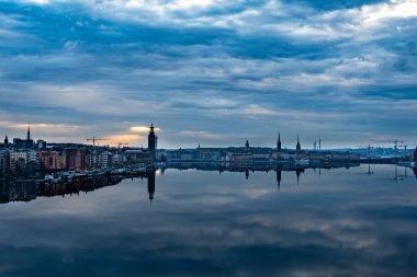 Stockholm, İsveç Batı Köprüsü 'nden belediye binasına doğru bir manzara ve sabahın erken saatlerinde Gamla Stan ve Riddarfjarden.