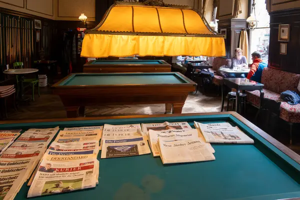 stock image Vienna, Austria April 5, 2024 A billiard table in a popular cafe is covered with an array of the daily newspapers.