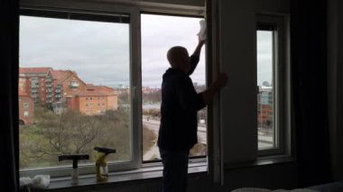 Stockholm, İsveç 'te bir adam bir apartmanın camlarını temizler.. 