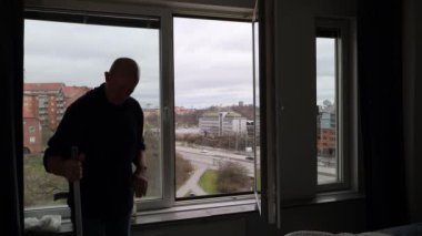 Stockholm, İsveç 'te bir adam bir apartmanın camlarını temizler.. 