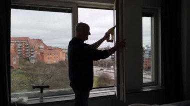 Stockholm, İsveç 'te bir adam bir apartmanın camlarını temizler.. 