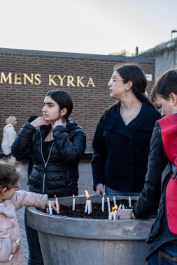 Stockholm, İsveç 12 Nisan 2024 İnsanlar Skarholmen 'in varoşlarında genç çete üyeleri tarafından öldürülen bir adam için mum yakıyor..