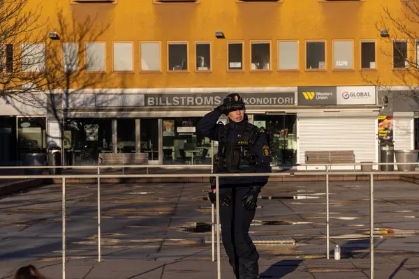 Stockholm, İsveç 12 Nisan 2024 Polis Skarholmen ehtnic banliyösünde genç çete üyeleri tarafından öldürülen bir adam için nöbet tutuyor..