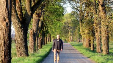Stockholm, İsveç Şafak vakti bir adam ağaçlık bir sokakta tek başına yürüyor..  