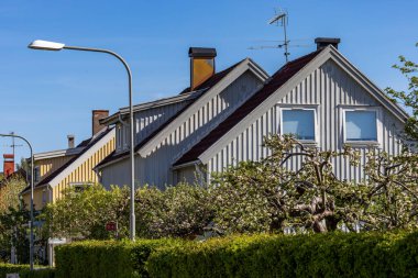 Stockholm, İsveç 15 Mayıs 2024 Şehrin güneyindeki yeşil ve yapraklı Gamla Enskede semtinde bir caddedeki konut evleri.