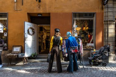 Stockholm, İsveç 21 Mayıs 2024 Eski moda kıyafet alışverişi yapan bir çift Gamla Stan 'de ikinci el bir mağazada oturuyordu..