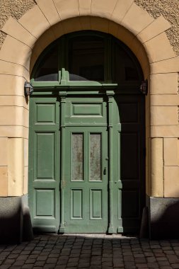 Stockholm, İsveç Bellmansgatan 'da bir apartmanın dışı, Sodermalm' da tarihi bir cadde ve yeşil bir kapı..