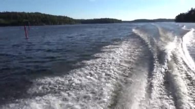Stockholm, İsveç Su sıçrama ve bir yaz akşamı Malaren Gölü 'nde orta hızda bir motorlu tekne uyanma. 