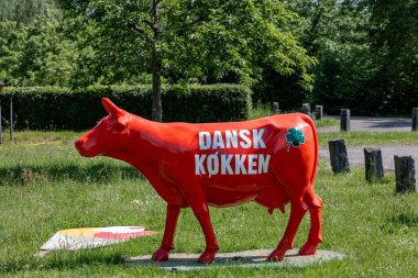 Hillerod, Danimarka 25 Mayıs 2024 'te yol kenarında bir restoran reklamı olarak kullanılan kırmızı inek figürü Danimarka' da şöyle der:.