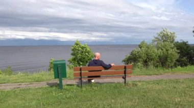 Kallaste, Estonya. Peipus Gölü kıyısında bir adam oturuyor ve Rusya 'ya bakıyor..