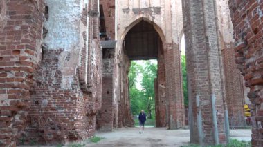 Tartu, Estonya Toome Hill Parkı 'ndaki Tartu Katedrali' nin kalıntıları arasında bir erkek turist yürüyor..