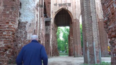 Tartu, Estonya Toome Hill Parkı 'ndaki Tartu Katedrali' nin kalıntıları arasında bir erkek turist yürüyor..