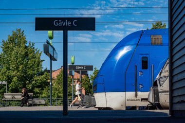 Gavle, Sweden June 25, 2024 Passengers on the platform run to catch a train at the Gavle Central Station. clipart