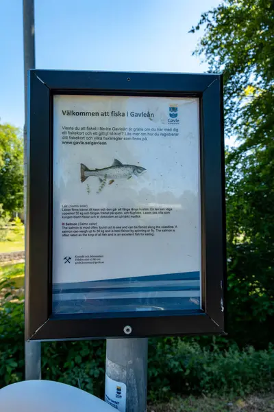 stock image Gavle, Sweden June 25, 2024 A tourism sign on the Gavlean, or Gavle River invites people to fish for salmon