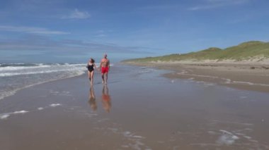 Hirtshals, Danimarka Sahilde yürüyen bir çift.  