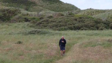 Hirtshals, Danimarka Deniz kenarındaki kumullarda bir adam yürüyor. 