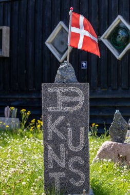 Lonstrup, Denmark, July 7, 2024 A granite block with a Danish flag and an engraving saying Danish Art in Danish. clipart