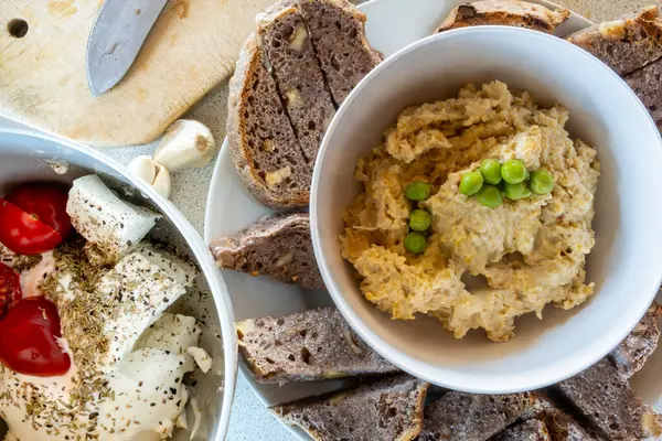 stock image A bowl of feta cheese and tomatoes with fresh walnut bread and hummus dip.