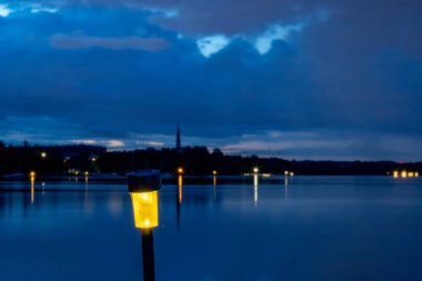 Stockholm, İsveç. Güneş enerjisiyle çalışan küçük bir gece lambası Malaren Gölü ve Ekero adası kıyı şeridini aydınlatır..