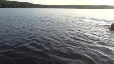 Stockholm, İsveç 'te bir adam gün batımında Malaren Gölü' nde yüzer.. 