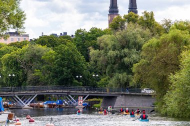 Stockholm, İsveç 26 Temmuz 2024 Kayakçılar şehir merkezindeki Palsundet Kanalı 'nda kürek çekiyorlar..