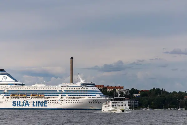 stock image Stockholm, Sweden July 26, 2024 A Silja Line ferry to Finland and smaller ferry boat in the Stockholm harbour.