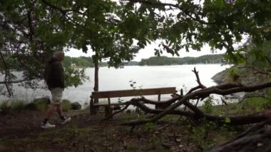 Stockholm, İsveç Nacka bölgesindeki Baltık Denizi 'nde küçük bir adada bir adam bankta oturuyor..