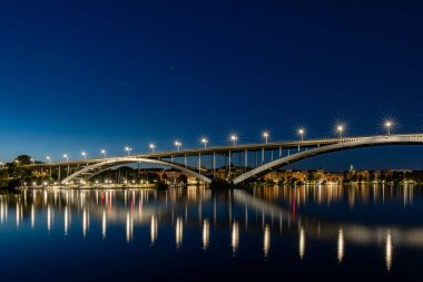 Stockholm, Sweden The Western Bridge or Vasterbron at night and reflections. clipart