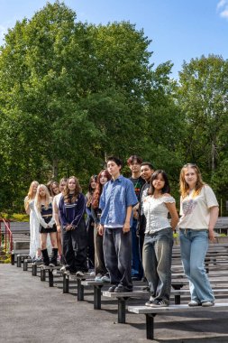 Stockholm, Sweden Aug 2, 2024 A group of young people gather in the Telefonplan district led by a community organizer to practice an outdoor Kpop-inspired dance show. clipart