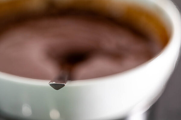 Масло и шоколад расплавляются в миске над паровой баней на плите.