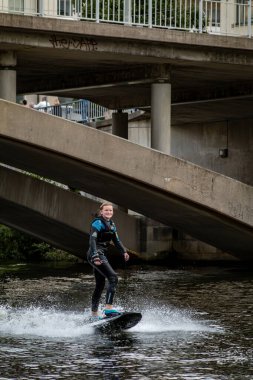 Stockholm, İsveç 14 Ağustos 2024 şehir merkezindeki bir kanalda sörf tahtası süren genç bir kadın..