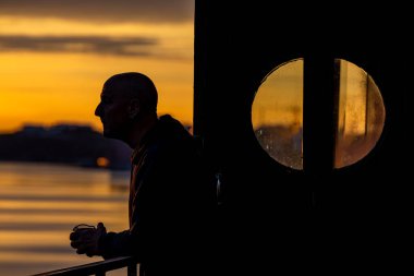 Stockholm, İsveç Baltık Denizi ve Kvarnholmen bölgesindeki güneşin doğuşuna bakan bir korkulukta dinleniyor..